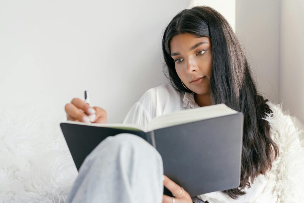 Person writing in a gratitude journal to reduce stress and doing the same can help you improve your heart health